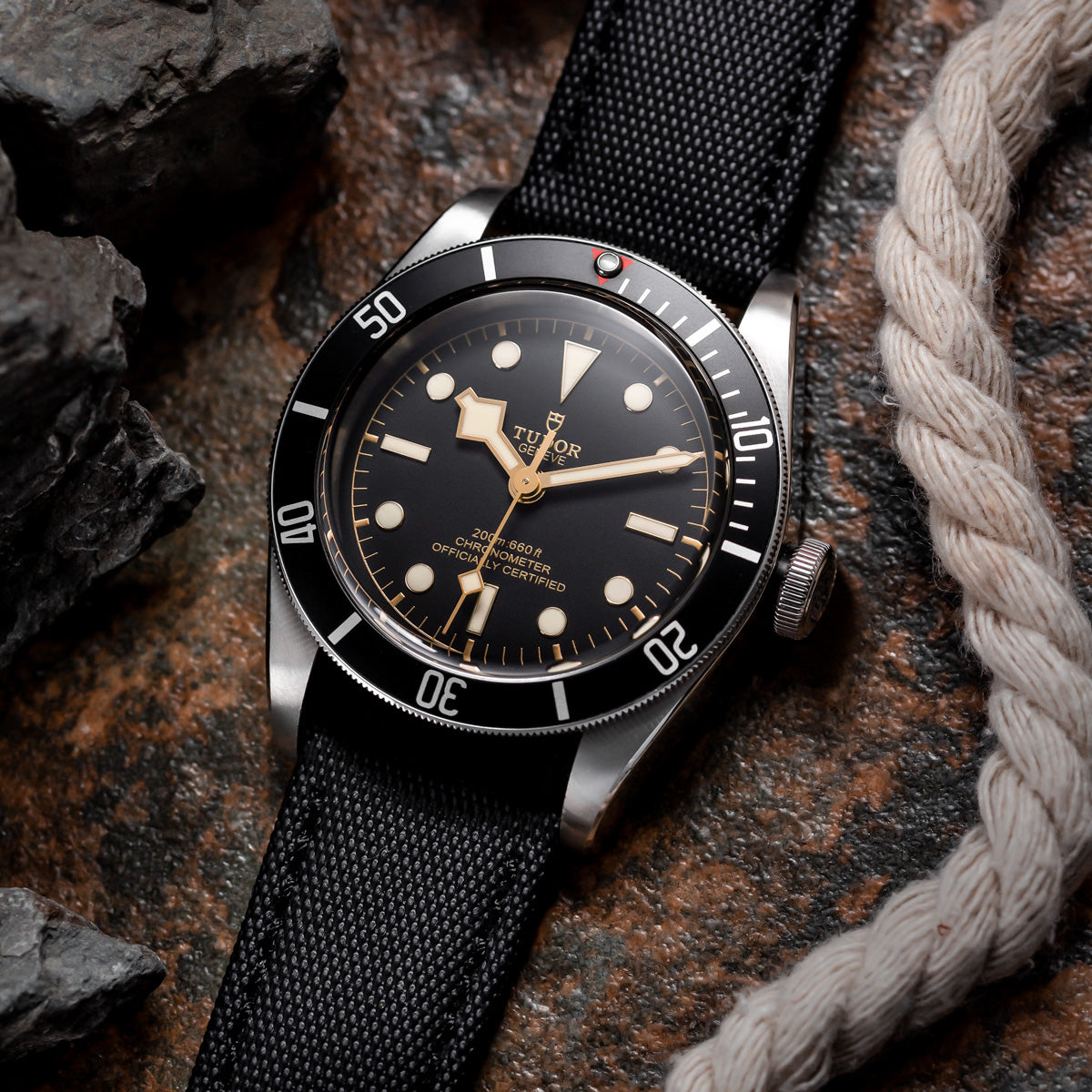 Black silcloth material watch strap with black stitching, fitted to a Tudor Black Bay mechanical wrist watch.