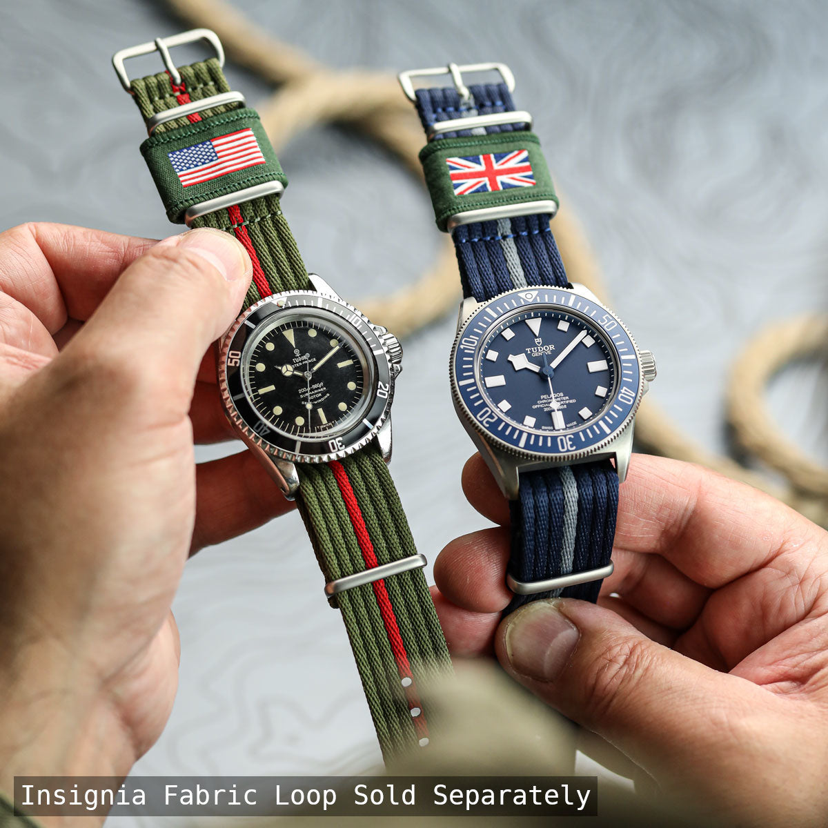 Two Tudor watches with fabric loops featuring American and British flags, held by a person.