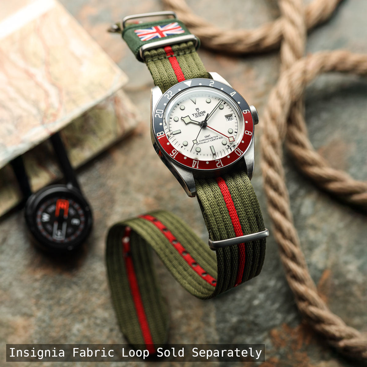 Tudor watch with green strap and red accents on a textured surface
