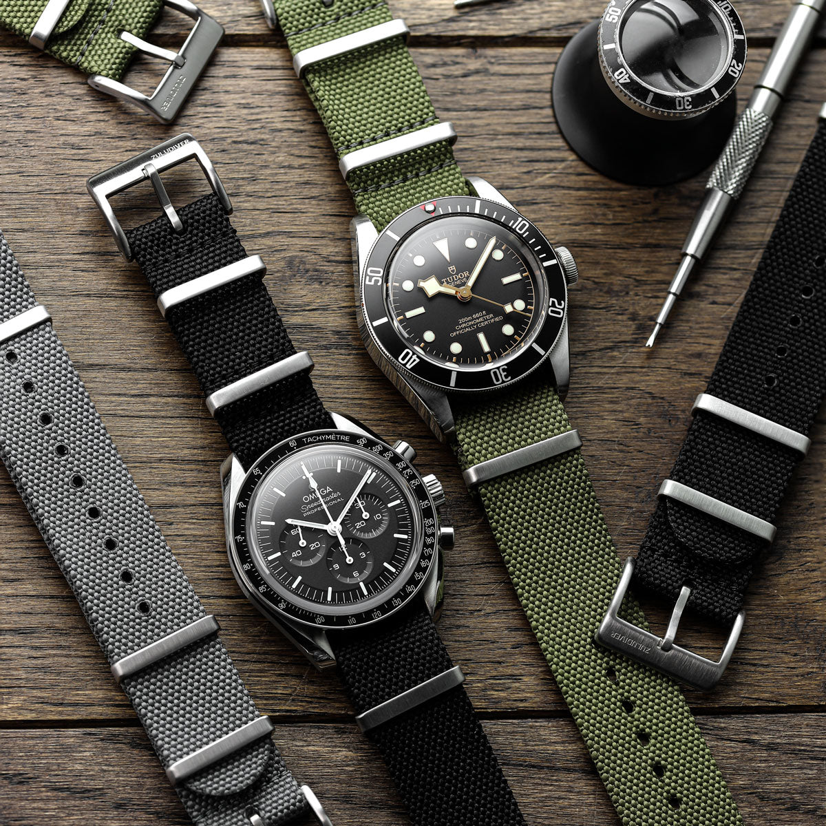 Black, grey and green woven canvas NATO watch strap with stainless steel fittings fitted to Omega Speedmaster and Tudor Black Bay